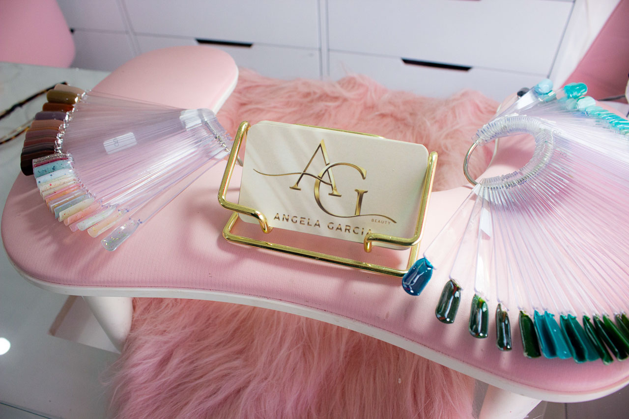 Mesa de manicura con cojín rosa y muestrarios