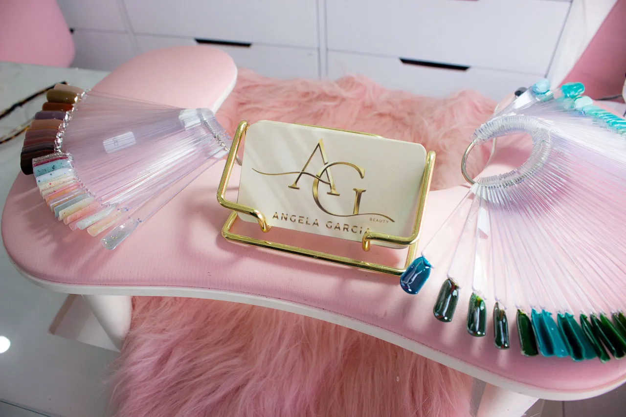 Mesa de manicura con cojín rosa y muestrarios