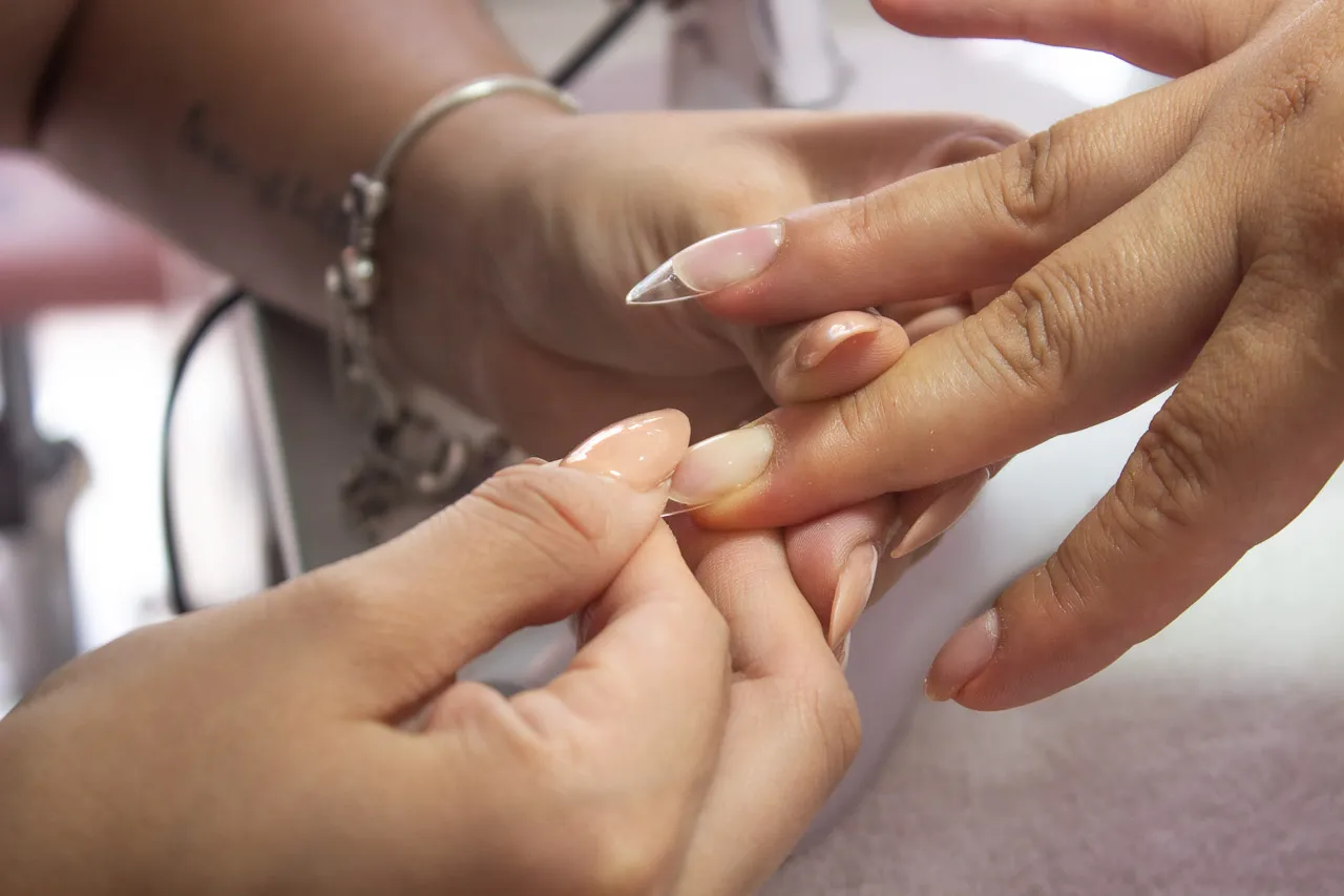 Manicurista ajustando tip transparente para uñas de gel