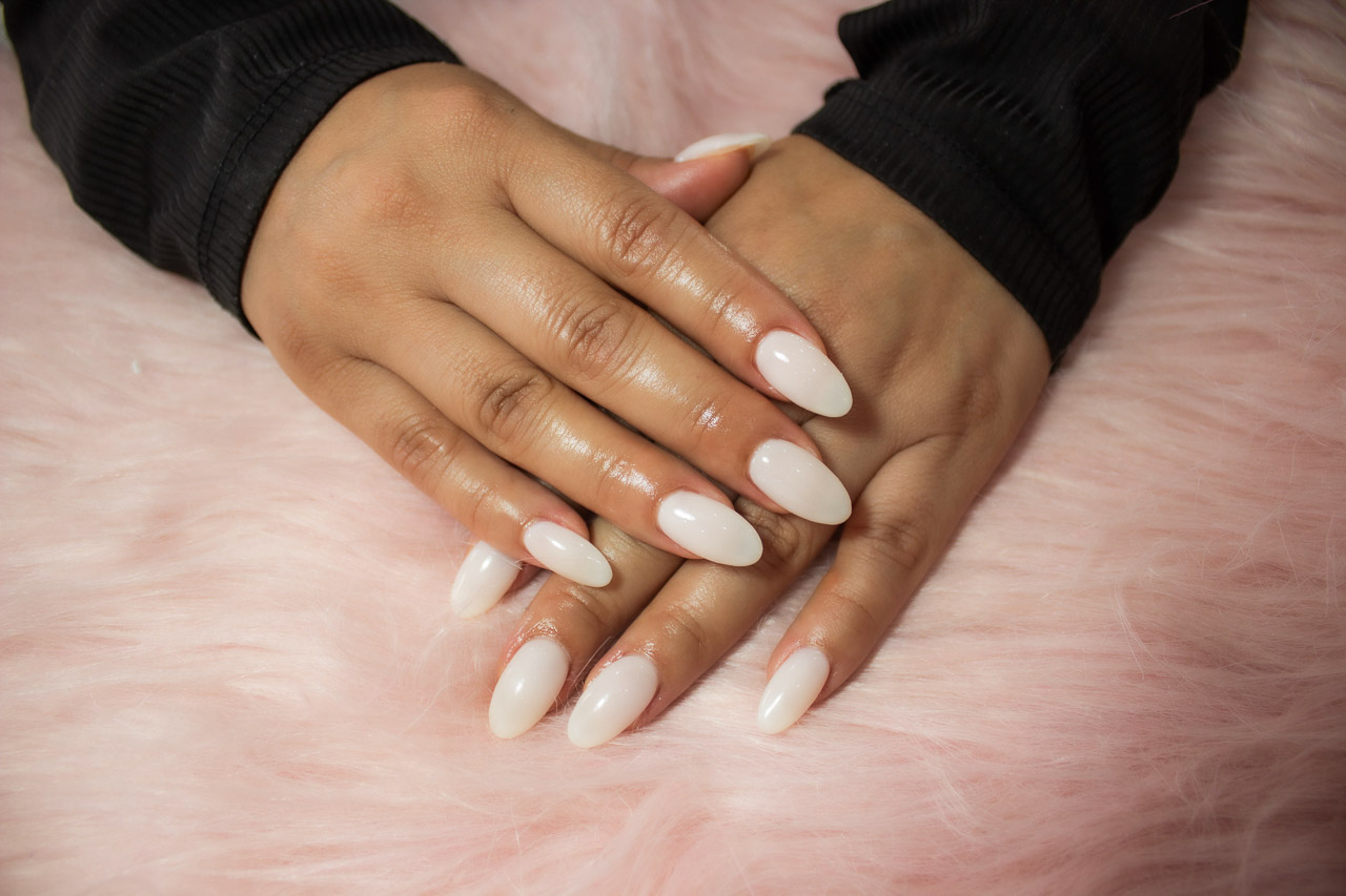 Diseño de uñas acrílicas almendradas en tono blanco lechoso